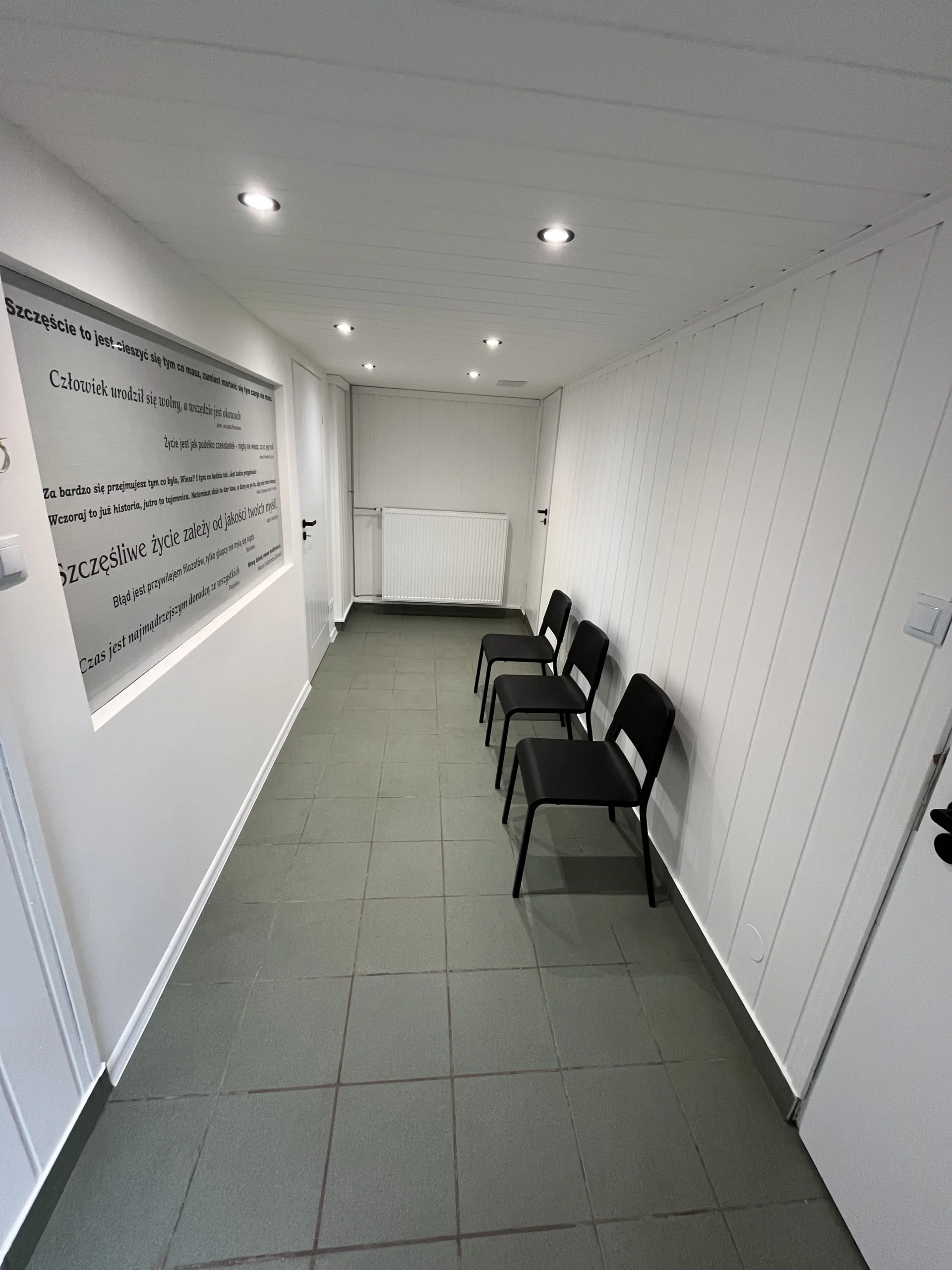 Jasny korytarz z miejscami do siedzenia w naszej pracowni w Gliwicach, gdzie wykonujemy Badania psychologiczne. Usługa obejmuje rozmowę i testy komputerowe, które pozwalają rzetelnie ocenić uwagę, pamięć, koordynację oraz szybkość reakcji i wydać orzeczenie.
